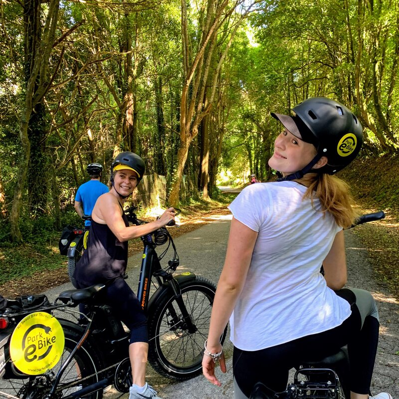 Jovens senhoras de uma estrada florestal em Sintra nas suas bicicletas olham para trás
