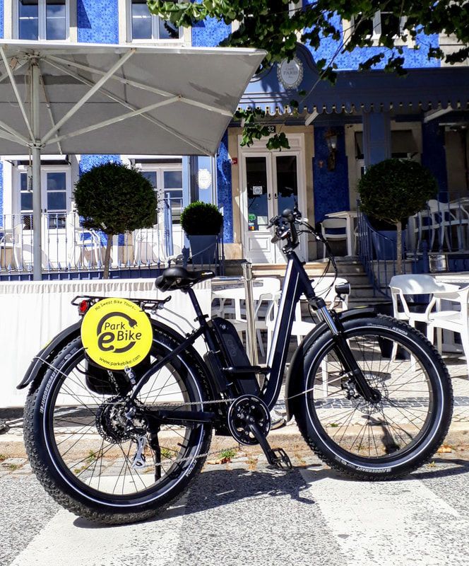 Bicicleta de pneu gordo em frente de um hotel muito azul em Sintra Portugal